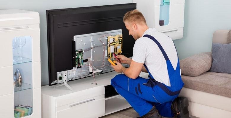 Professional TV technician repairing an LED TV at home