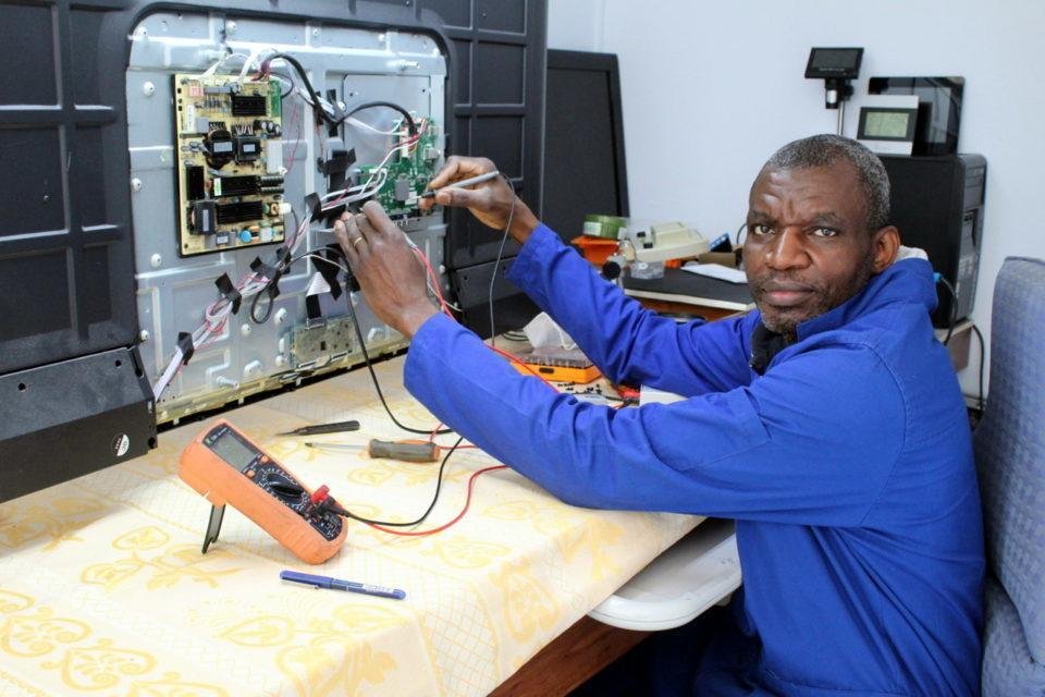 Professional TV technician repairing an LED TV circuit board
